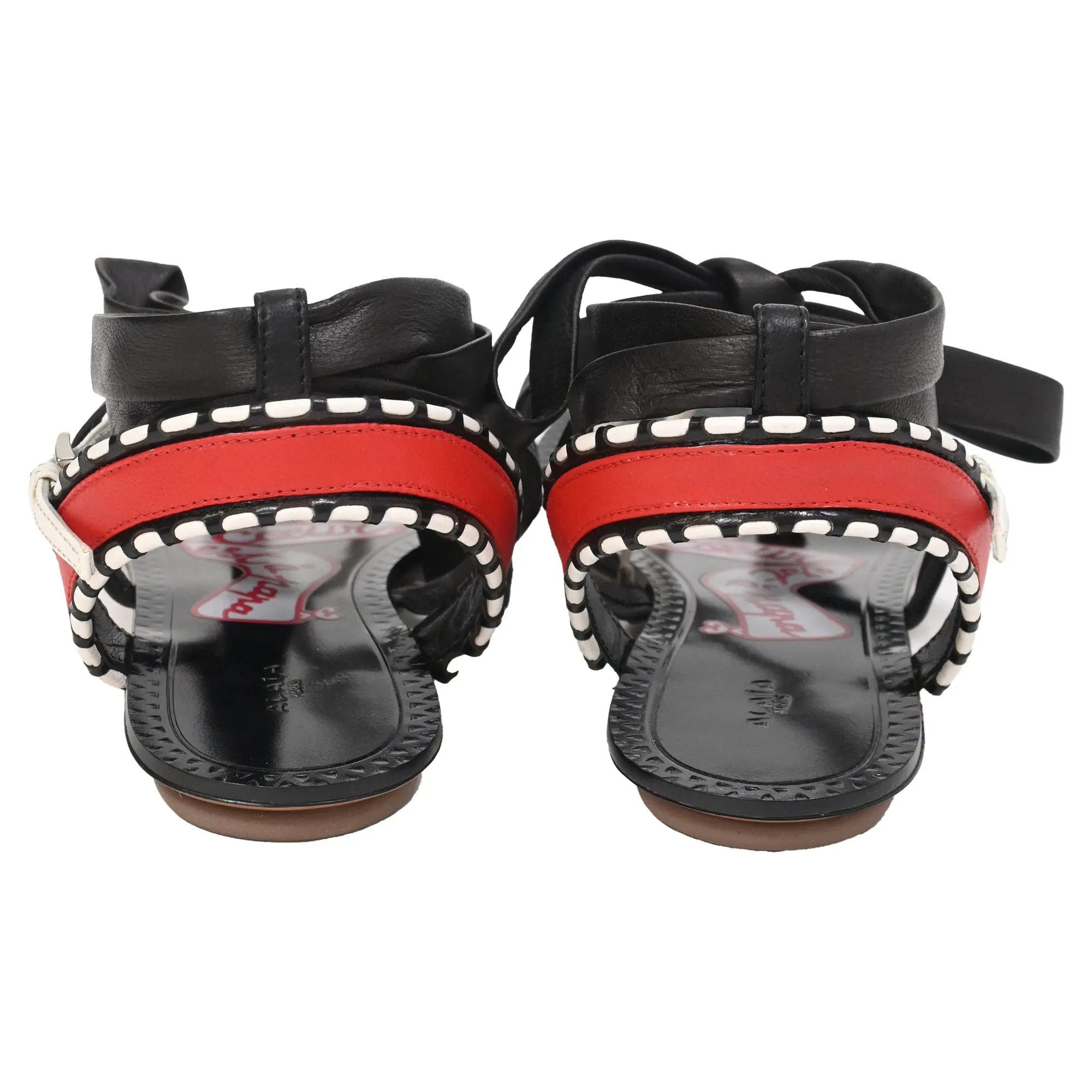 Alaïa Graphic Print Gladiator Sandals in Black Leather